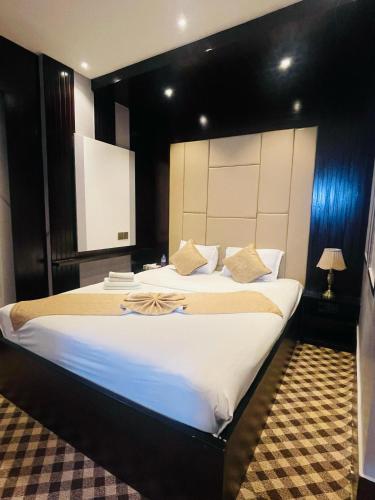 a bedroom with a large bed with a large headboard at Hotel Istanbul & Spa in Sylhet