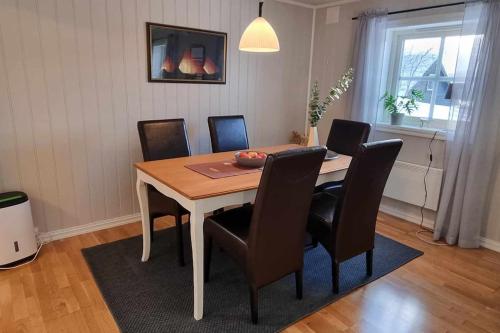 a dining room table with black chairs and a table and a table at Leilighet på Bekkeli, Beito. in Beitostøl