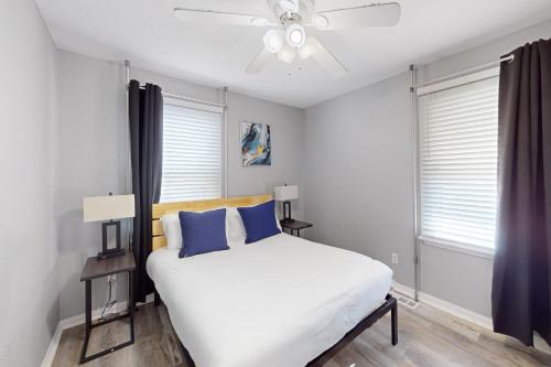 - une chambre avec un lit blanc et des oreillers bleus dans l'établissement Mid America House, à Midwest City