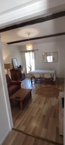 un salon avec une table et un canapé dans l'établissement Appartement lumineux centre, à Cessenon