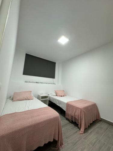 Habitación con 2 camas y TV de pantalla plana. en NAUZAYARA 6, en La Frontera