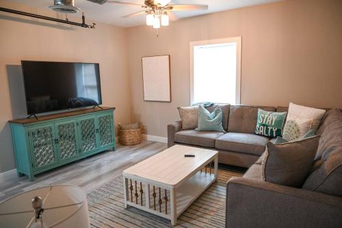 a living room with a couch and a tv at The Borden Room in Biloxi