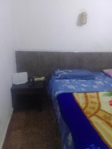 a small bedroom with a bed and a table at Shark in Paso de los Libres