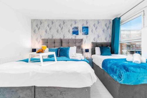 2 camas en una habitación de color azul y blanco en 2 Bedroom Birmingham City Centre Apartment with Pool Table - Free Parking, en Birmingham