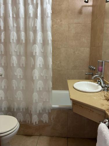 baño con lavabo y cortina de ducha con elefante en Departamento en Colastine Norte en Colastiné