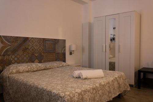 una camera da letto con un letto e un asciugamano sopra di Affittacamere le scale a Castellammare del Golfo