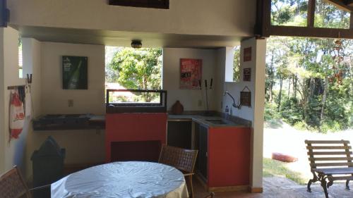 cocina con fregadero, mesa y sillas en Sítio Vila de Santa Barbara, en Caeté