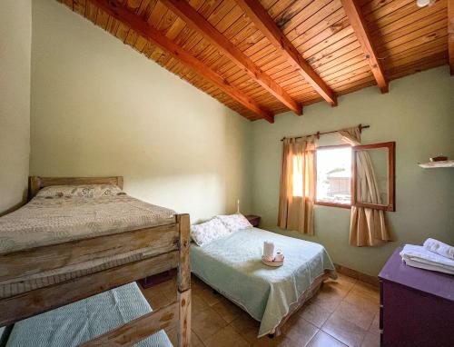 a bedroom with two beds and a window at Narciso Home in Cafayate