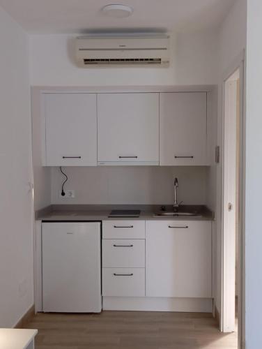 a white kitchen with white cabinets and a sink at El Levante in Tarifa