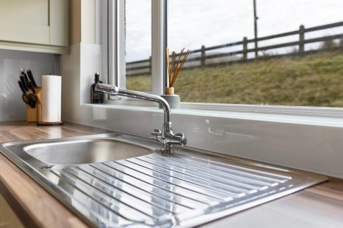 a kitchen sink and a window with a view of a field at Sperrin Mountain Escape in Derry Londonderry