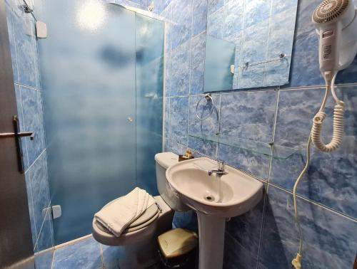 uma casa de banho com um lavatório, um WC e um chuveiro em Pousada Casa de Campos Guest em Campos do Jordão