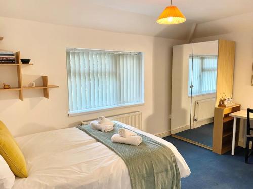 4 bed House Royal Leamington Spa with free parking في ليمينغتون سبا: غرفة نوم عليها سرير وفوط