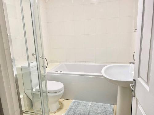 4 bed House Royal Leamington Spa with free parking في ليمينغتون سبا: حمام ابيض مع مرحاض ومغسلة