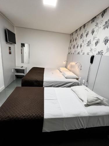a hotel room with two beds and a wall at Life Hotel in Canoas