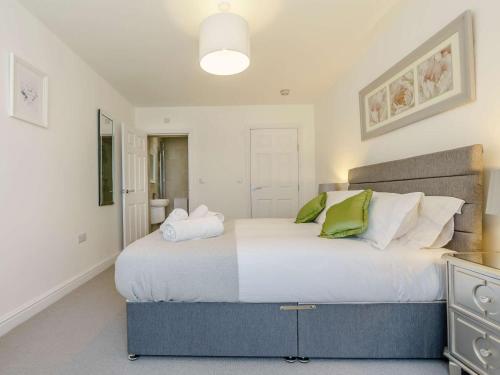 a bedroom with a large white bed with green pillows at 3 Bed in Wooler 83975 in Wooler