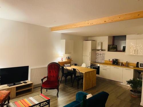 a living room with a table and a kitchen at Chez Gaston in Chambon-sur-Lac