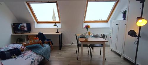 um quarto com uma mesa, uma cama e uma sala de jantar em Appartement Tout équipé en Hyper-Centre avec Parking Privé et Gratuit - Vue sur la Ville et Château de Caen em Caen