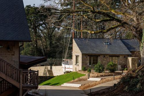 a house with a yard with a stone house at Domaine de Locguénolé & Spa - Relais & Chateaux in Kervignac
