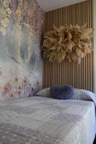 a bedroom with a bed with a painting on the wall at Apartamento Ladevesa in Elche