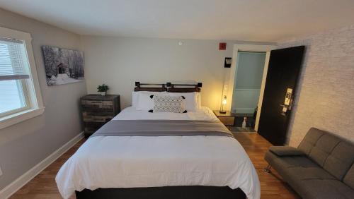 a bedroom with a large bed and a couch at Gunstock Inn & Suites in Gilford