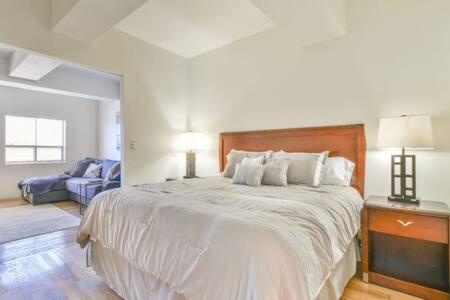 a bedroom with a large bed and a couch at The Executive Loft - Walk to Sanford Stadium in Athens