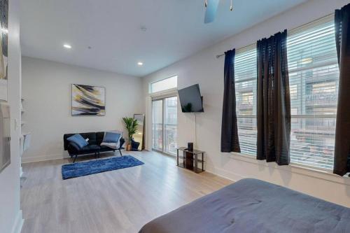 Habitación con cama, silla y TV. en A VIBE in DEEP ELLUM! en Dallas
