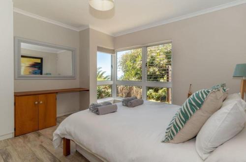 a bedroom with a large white bed and a window at The Sea Soul in Cape Town