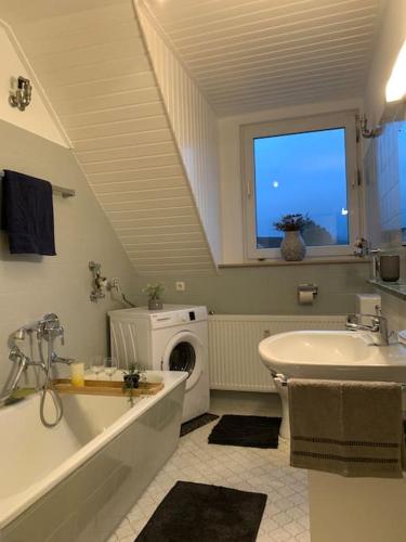 a bathroom with a sink and a washing machine at Ferienwohnung Wanderlust in Bad Rothenfelde