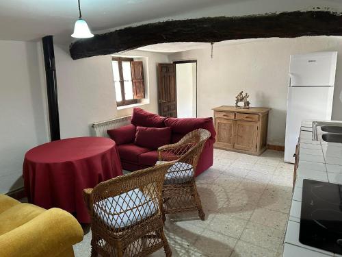 a living room with a red couch and a table at Casa Rural El Reloj in Salobralejo