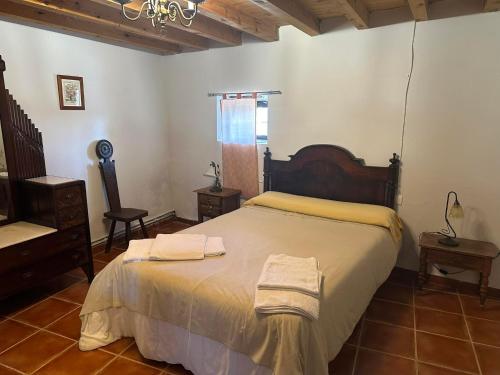 a bedroom with a bed with two towels on it at Casa Rural El Reloj in Salobralejo