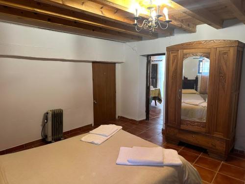 a bedroom with a bed and a dresser with towels on it at Casa Rural El Reloj in Salobralejo