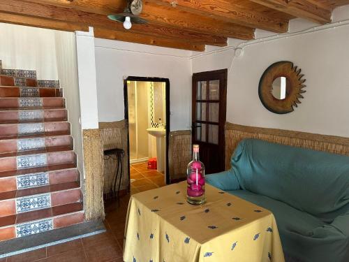 a living room with a green couch and a table at Casa Rural El Reloj in Salobralejo