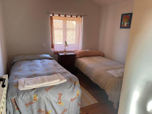 a bedroom with two beds and a window at Casa Rural El Reloj in Salobralejo