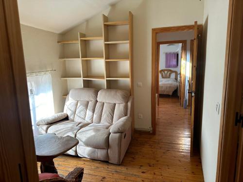 a living room with a white couch and shelves at Casa Rural El Reloj in Salobralejo