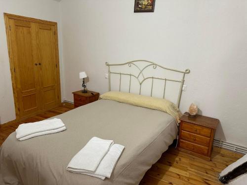a bedroom with a bed with two towels on it at Casa Rural El Reloj in Salobralejo