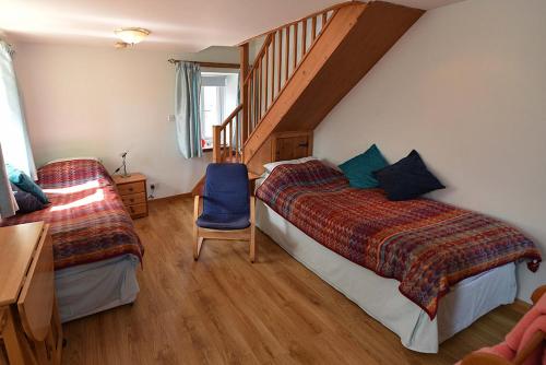 a bedroom with two beds and a staircase at Winkston Holiday Accommodation in Peebles