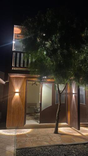 a house with a tree in front of a building at Lofts Urbano in Urubici