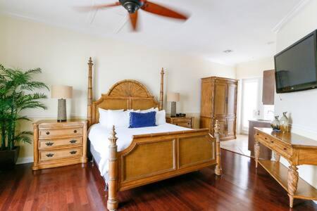 a bedroom with a bed with a ceiling fan at Grand Marina Suite by Brightwild-Waterfront Condo in Key West