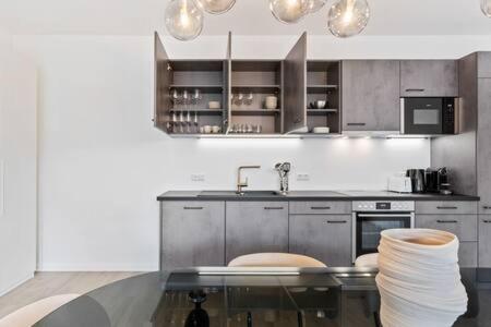 a kitchen with a glass table and a sink at Stylish Retreat in Bivange Roeser in Roeser
