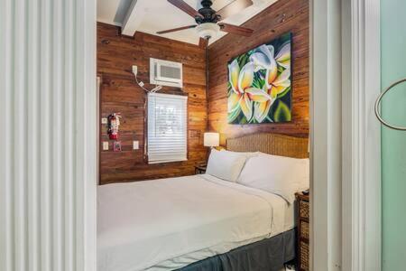 a bedroom with a bed and a painting on the wall at Coral Cove #1 by Brightwild in Key West