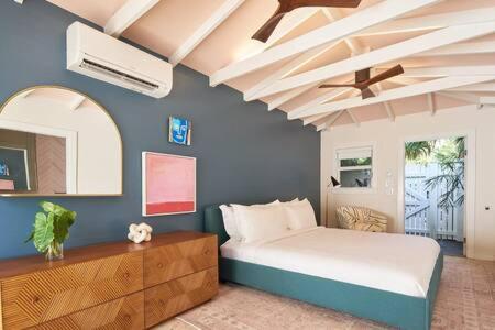 a bedroom with a bed and a ceiling fan at Takeover at the Grand Maloney by Brightwild in Key West
