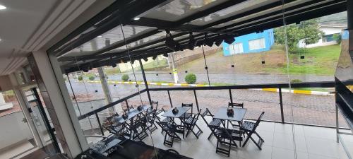 a room with tables and chairs and a large window at Hotel em Timbo Grande 