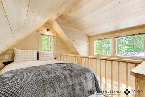 um quarto com uma cama num chalé de madeira em The Mulberry in Treehouse Grove at Norton Creek em Gatlinburg