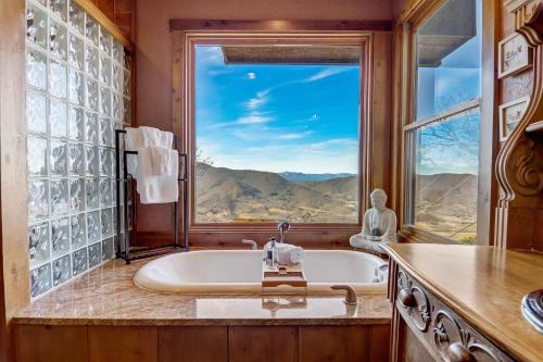 a bathroom with a tub and a large window at Barkwells in Mills River