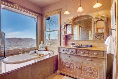 a bathroom with a tub and a sink and a window at Barkwells in Mills River