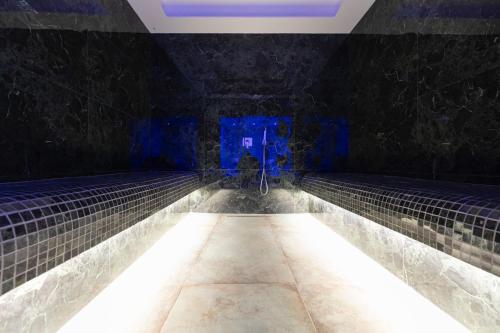 a dark room with a pool of water with lights at Destiny Hotel & SPA in Tirana