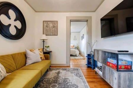 a living room with a couch and a flat screen tv at Pet Friendly Bungalow Steps to Inman Park in Atlanta