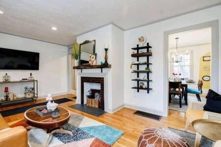 a living room with a fireplace and a table at Pet Friendly Bungalow Steps to Inman Park in Atlanta