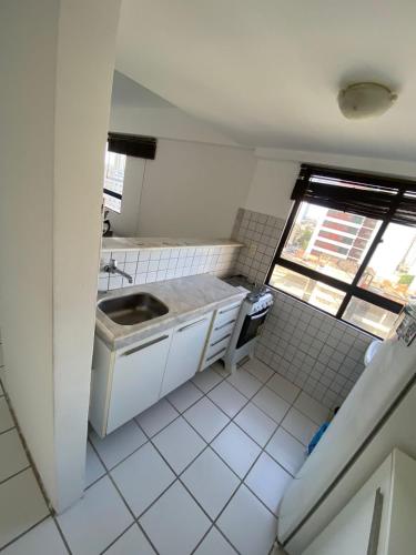 a kitchen with a sink and a tiled floor at Flat no melhor lugar de boa viagem in Recife