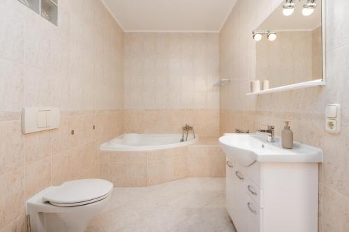 e bagno con servizi igienici, lavandino e vasca. di Zala Hills Apartman - Batthyány Villapark a Zalacsány
